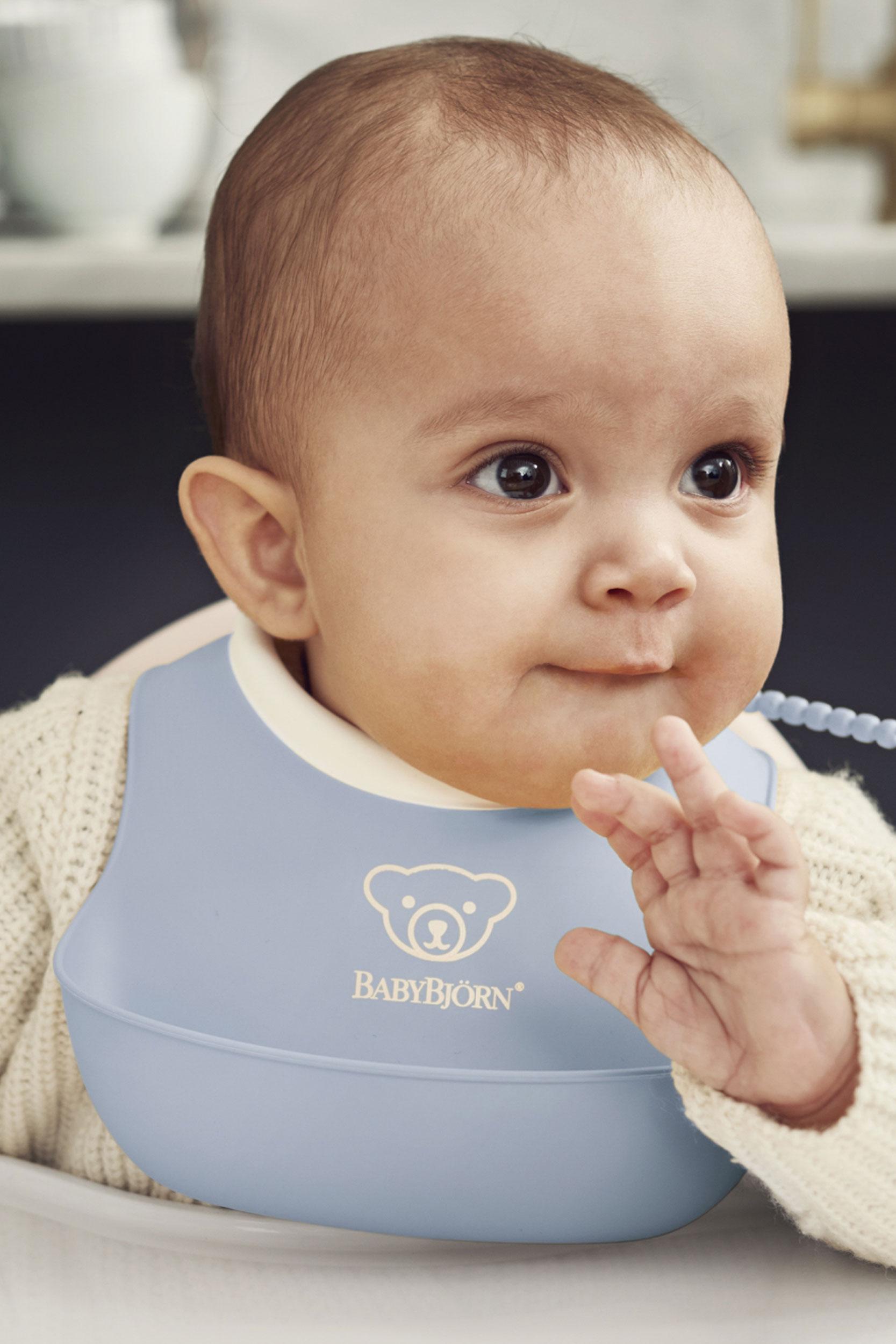 Small Baby Bib in powder blue BPA-free plastic with spill pocket - BabyBjörn