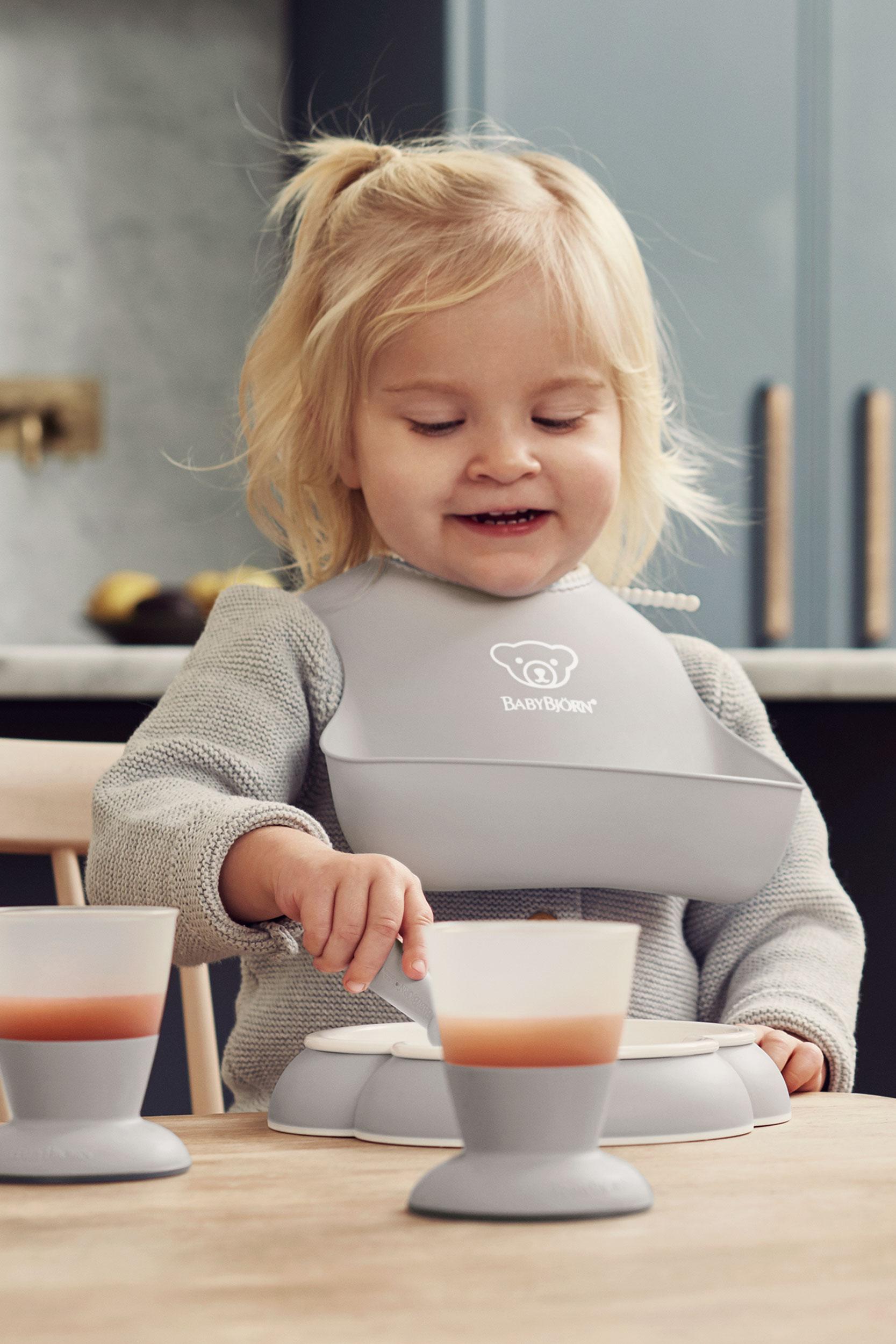 Baby Bib in grey BPA-free plastic with deep spill pocket - BabyBjörn