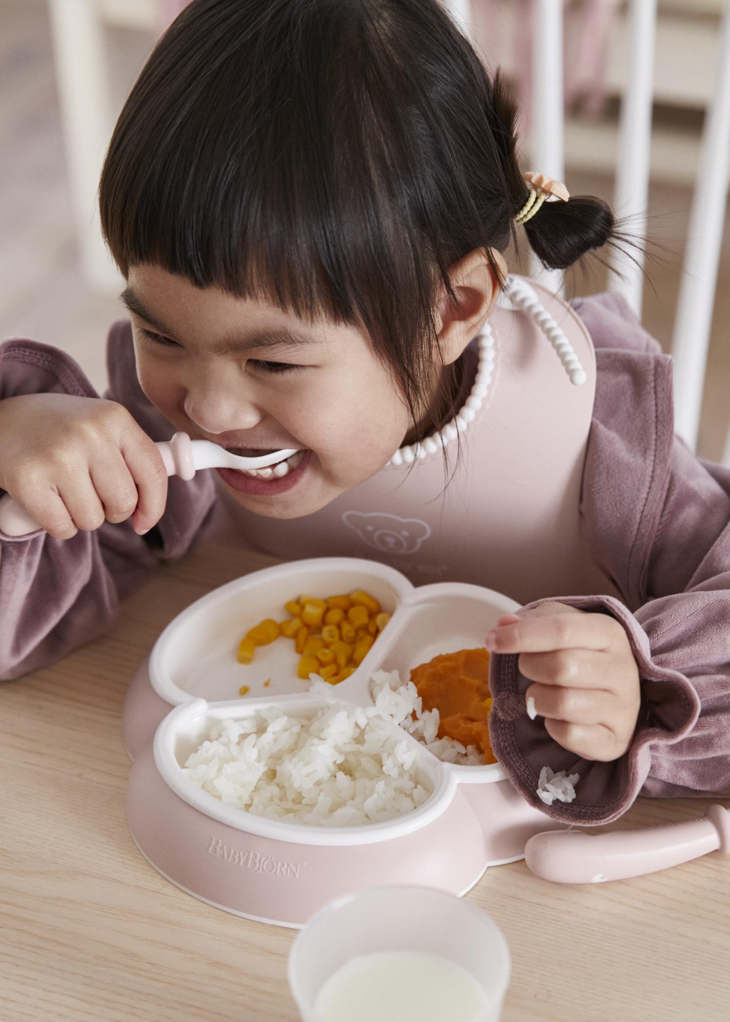 Dinnerware set in powder pink with baby plates, cup and cutlery and a bib with spill pocket - BabyBjörn